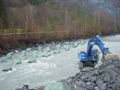 Mit der Baggerschaufel werden die Steinblöcke mit einem Gewicht von vier bis sechs Tonnen in einem vorgegebenen Raster auf der Flusssohle platziert