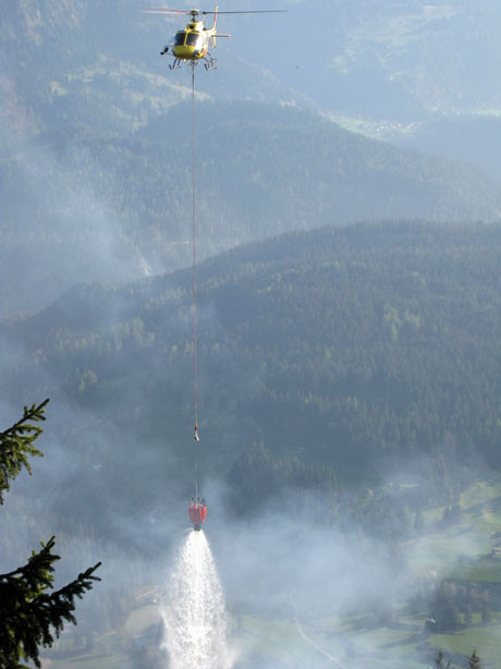 Ein Löschhelikopter beim Abwerfen des Wassers