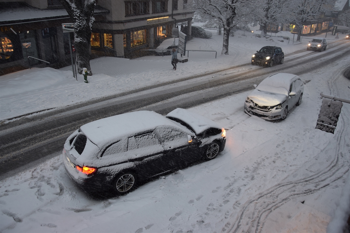 Blick aus der Vogelperspektive auf die beiden an der Front stark beschädigten Autos. Die Fahrbahn ist mit Neuschnee bedeckt.