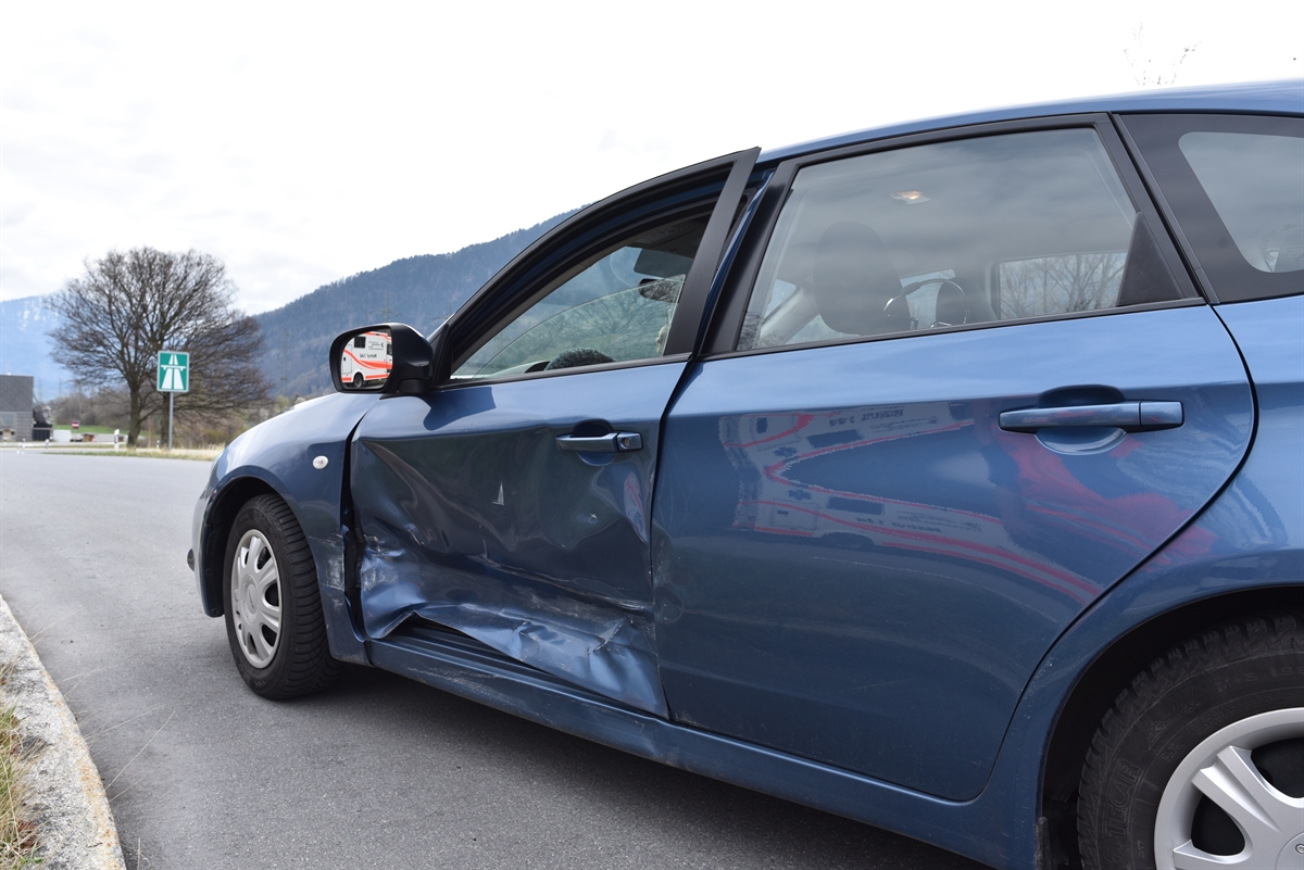 Das an der Fahrertüre und am Seitenschweller stark beschädigte Auto steht auf der Einfahrt der A13.  