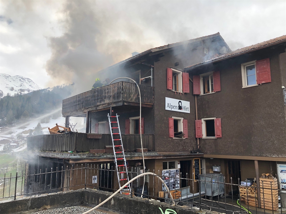 Das Holzhaus, daraus quillt Rauch hervor, aus einer anderen Perspektive. 
