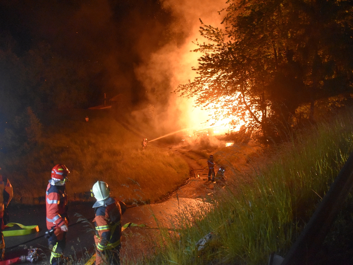 Feuerwehrleute bei den Löscharbeiten. Stall in Vollbrand.