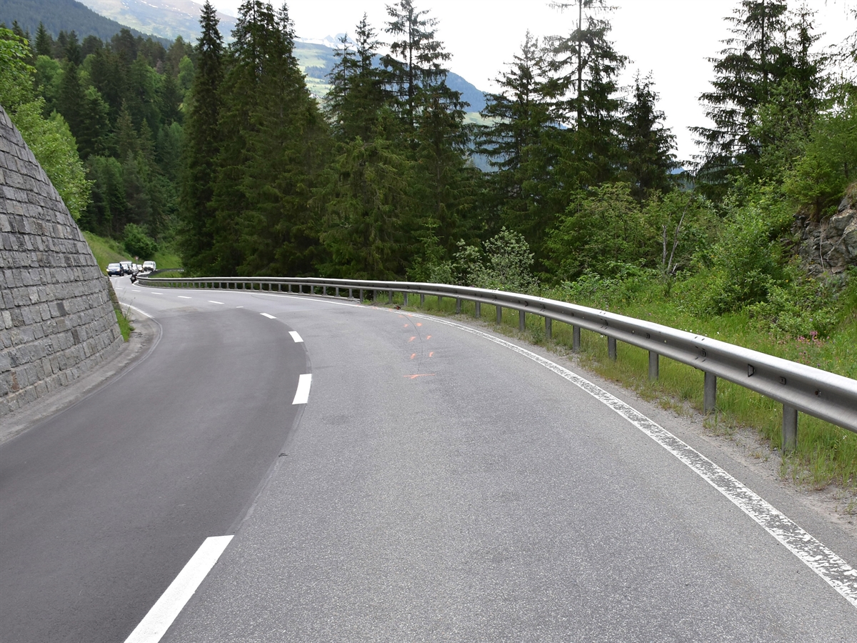 Linkskurve der Engadinerstrasse H27 bei der Örtlichkeit Plattamala. Auf der Fahrbahn Bremsspur des Motorrades in Richtung rechtsseitige Leitplanke.