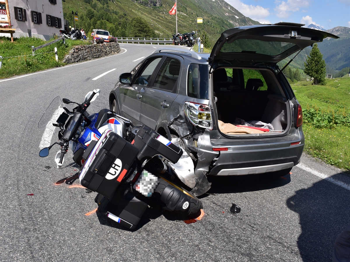 Beschädigtes Auto hinten links sowie das danebenliegende Motorrad.