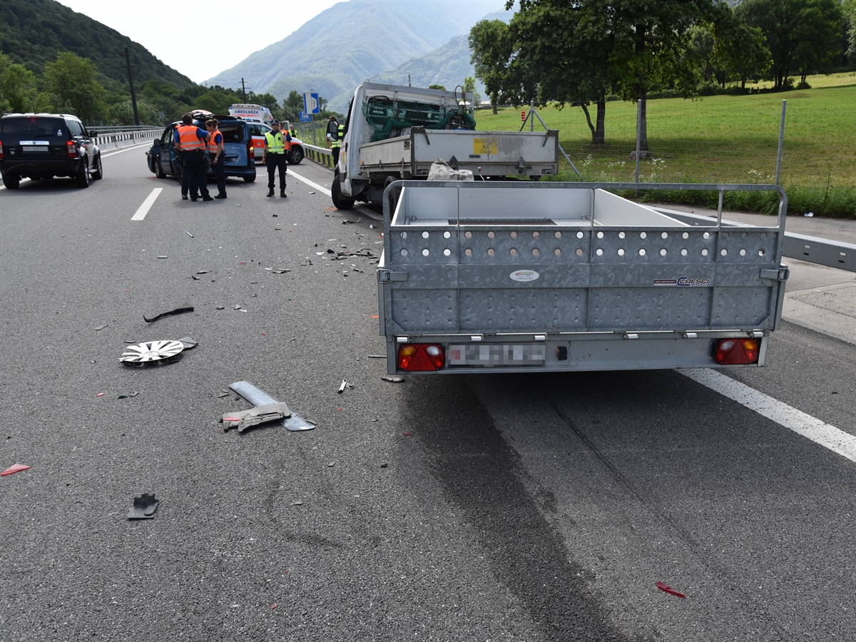 Die zweispurige Fahrbahn der A13 in Richtung Bellinzona. Im Vordergrund der Lieferwagen mit Anhänger. Im Hintergrund Polizisten der Kapo GR und Kapo TI.