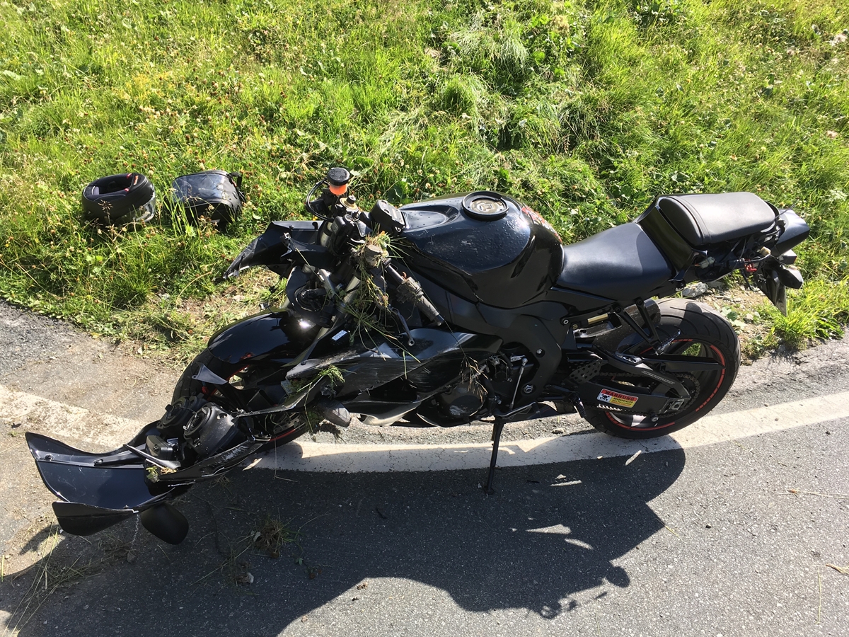 Das total beschädigte Motorrad steht auf dem Seitenständer auf der Fahrbahn.