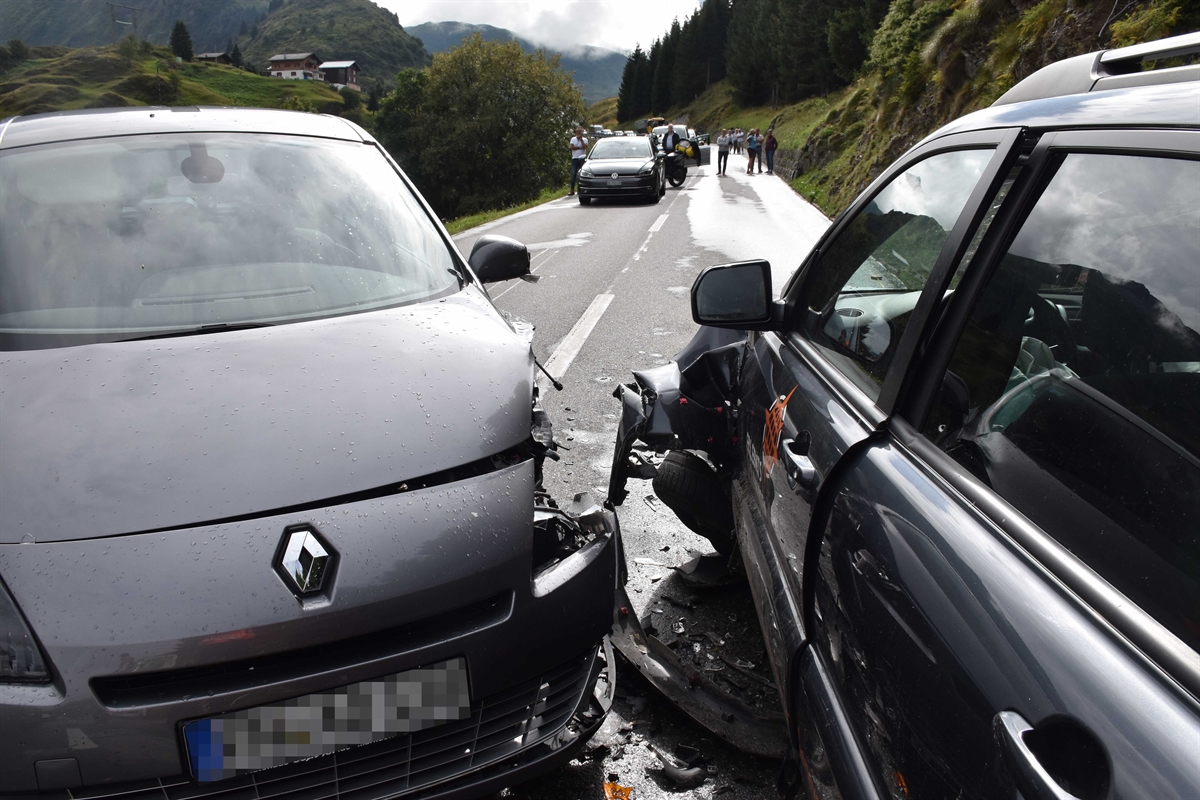 Die beiden total beschädigten Autos, im Hintergrund wartende Verkehrsteilnehmende.