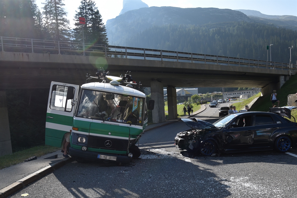 Am linken Fahrbahnrand von vorne der auf der Fahrerseite stark beschädigte Kleinbus. Rechts davon quer auf der Strasse das frontal und links stark beschädigte Auto.