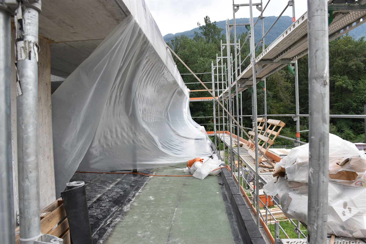 Aufnahme des ersten Stocks des Rohbaus. Links die durch Wind eingebauchte Plastikplane, rechts das Fassadengerüst.