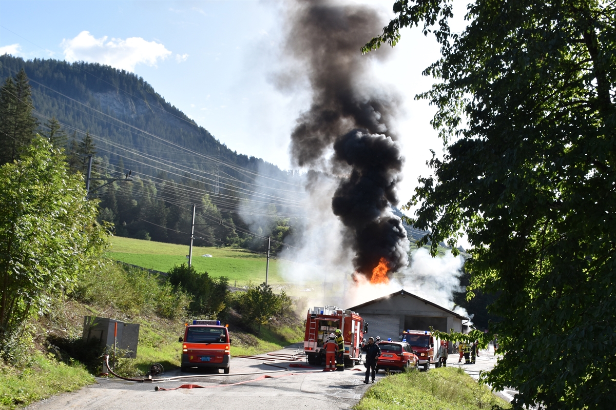 Brennende Dieseltanks mit Feuerwehrfahrzeugen und -leuten