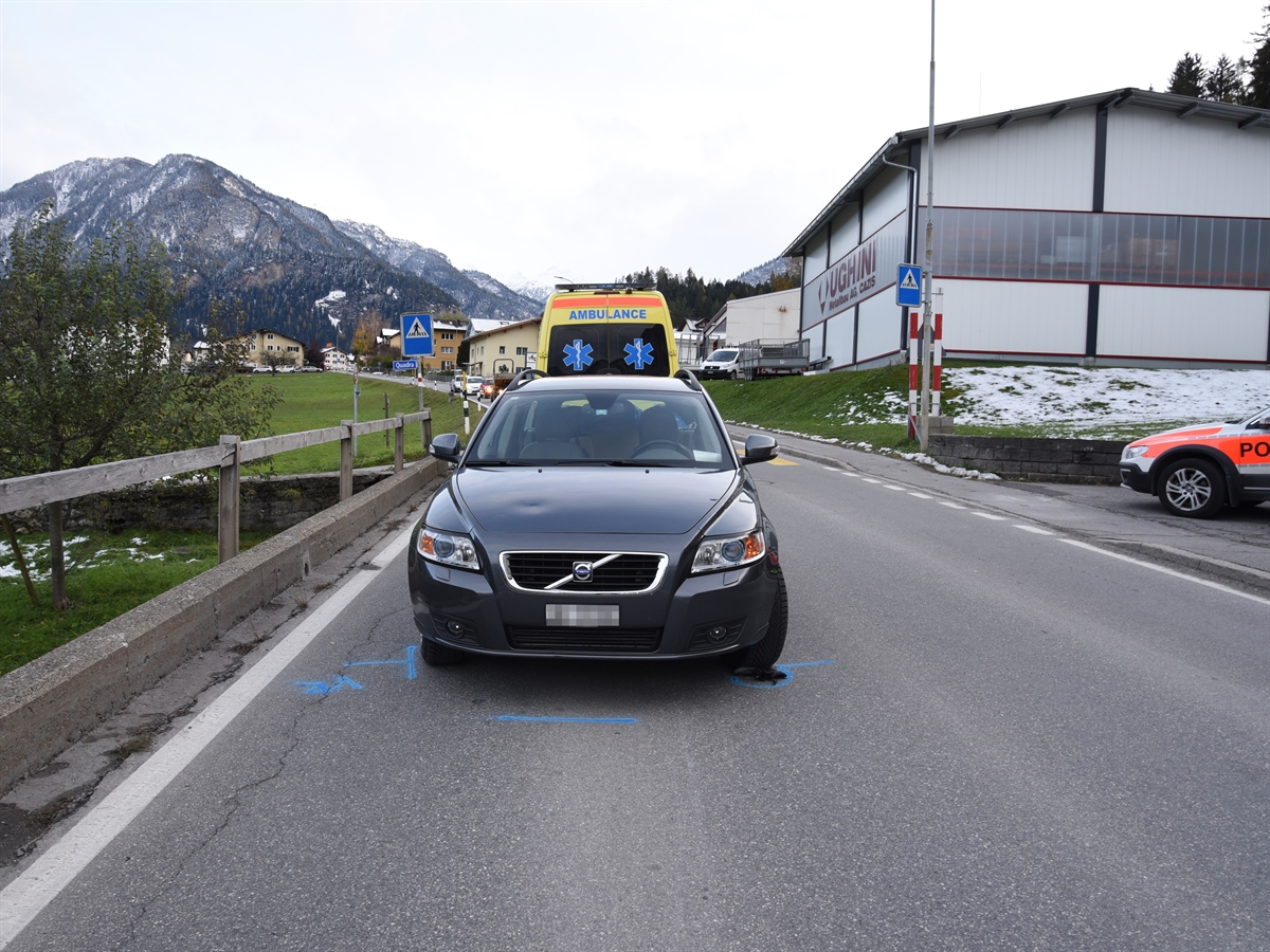 Beteiligtes Auto mit der Ambulanz im Hintergrund. Unter dem vorderen Rad rechts ist noch ein Schuh des Mädchens eingeklemmt.