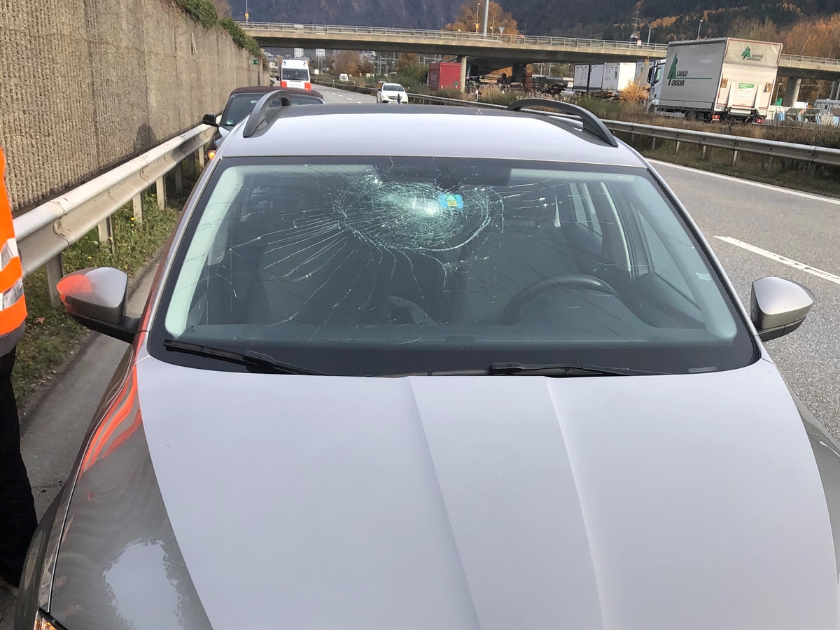 Das beschädigte Auto von vorne gesehen auf dem Pannenstreifen. Auf der rechten Seite die Südspur und die Nordspur der Autobahn A13.