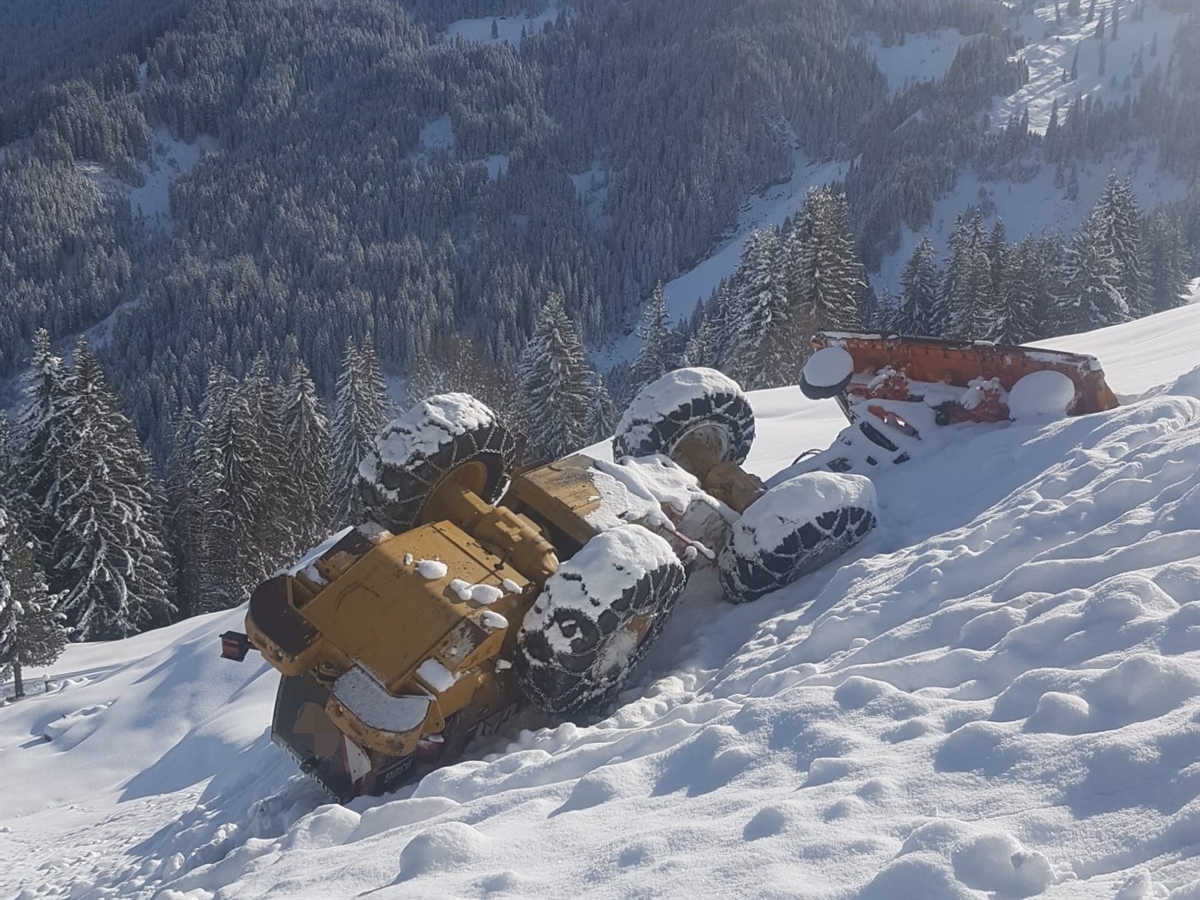 Pneulader im Schnee auf dem Dach liegend