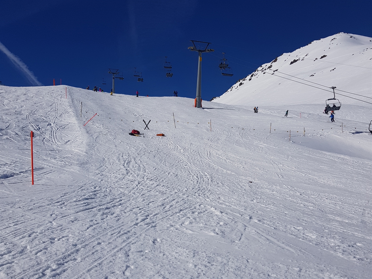 Skipiste mit der Sesselbahn Meierhoftäli. Die leicht abfallende Piste wurde abgesperrt. Bei der Kollisionsstelle liegt ein roter Rucksack.