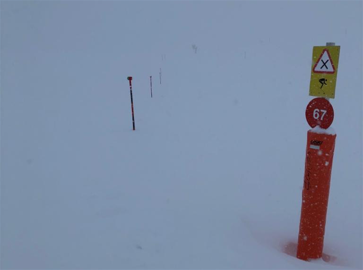 Piste mit Schild im Nebel