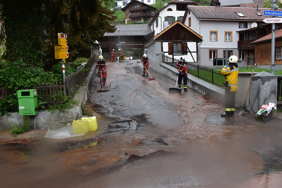 Feuerwehrleute putzen die Strasse