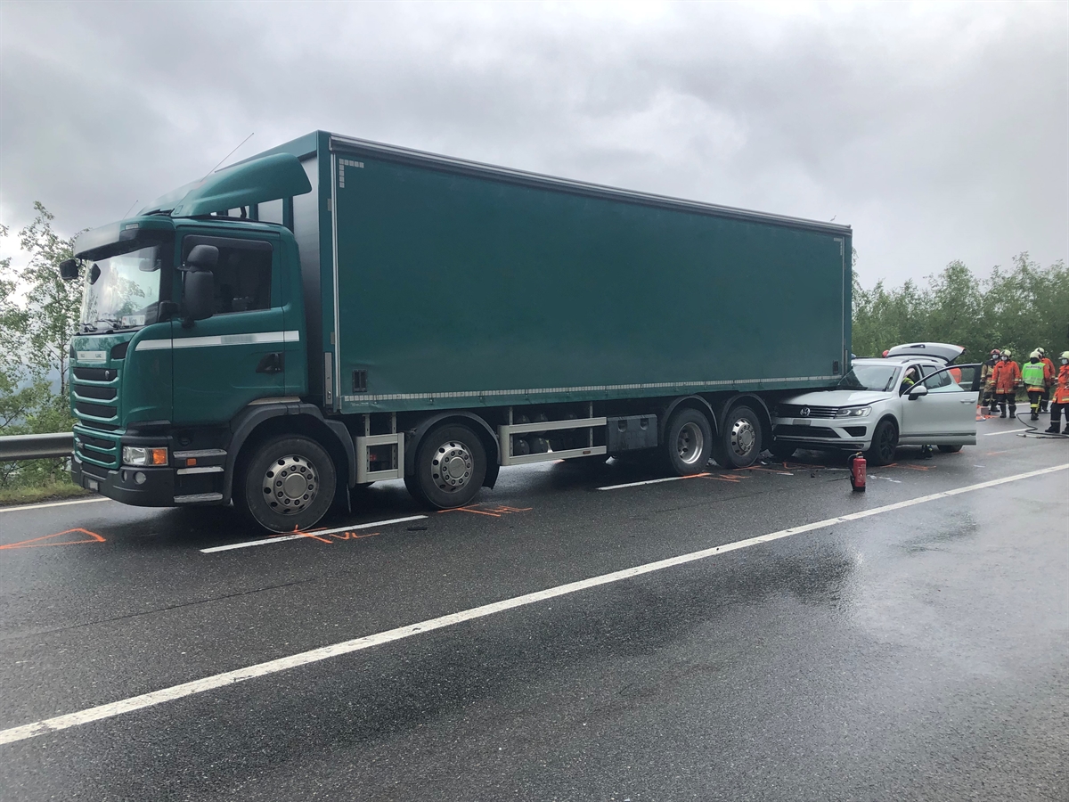 Ein silbergrauer Personenwagen ist unter dem hinteren Überhang des Lastwagens eingeklemmt. Die Frontscheibe des Autos ist auf der Beifahrerseite durch das Heck des Lastwagens eingedrückt.