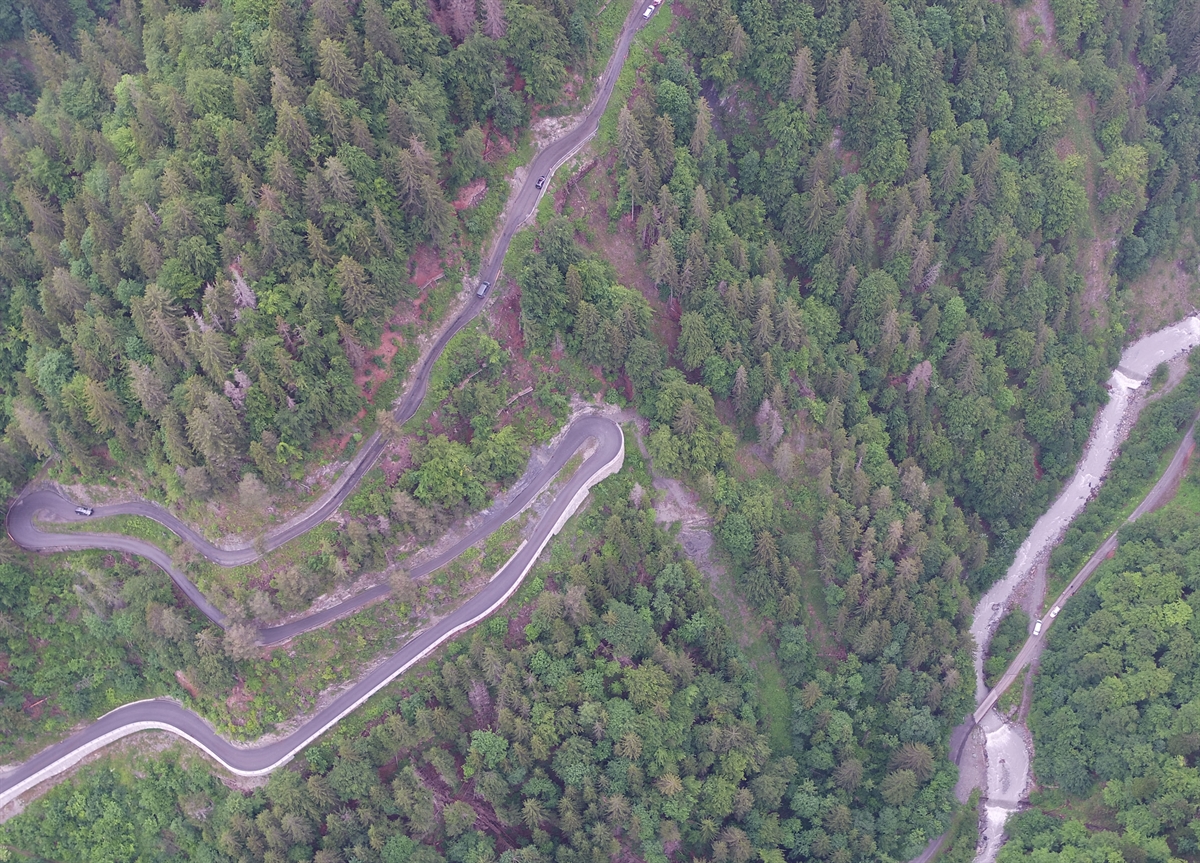 Strasse, steiles Gelände und Bach