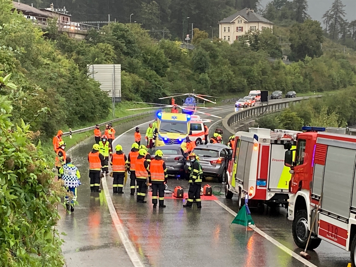 Feuerwehrleute, Feuerwehrautos, verunfallte Autos, Regahelikopter und Tripple A Helikopter. Übersichtsaufnahme der Unfallstelle