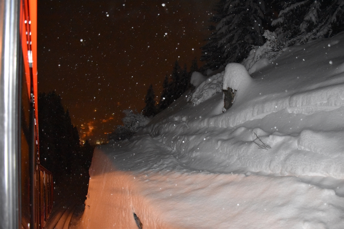 Übersichtsaufnahme aus der Kabine der Parsennbahn auf die Stützmauer. Über der Mauer sind Spuren eines Snowboarders ersichtlich.
