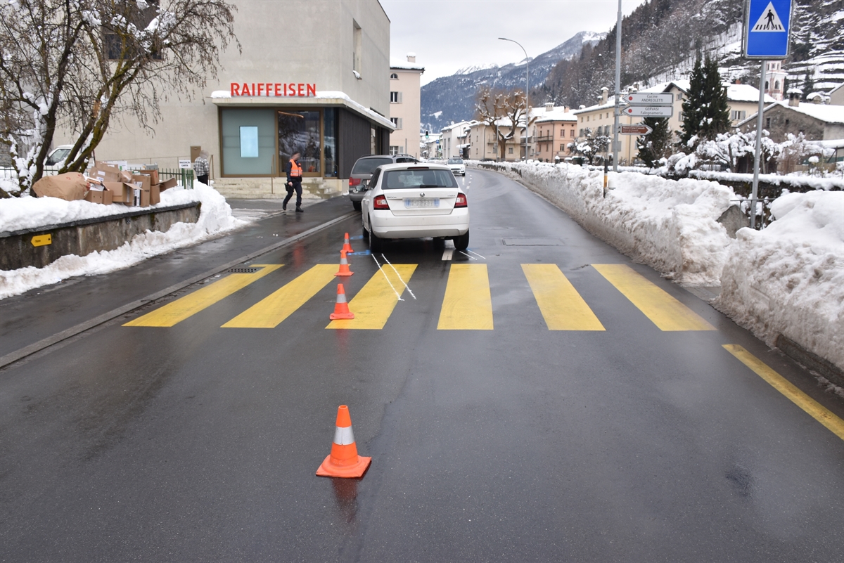 Übersicht der Strasse. Im Strassenverlauf sind Molankegel aufgestellt für den Spurenverlauf. Ein Personenwagen steht nach dem Fussgängerstreifen mitten auf der Strasse.