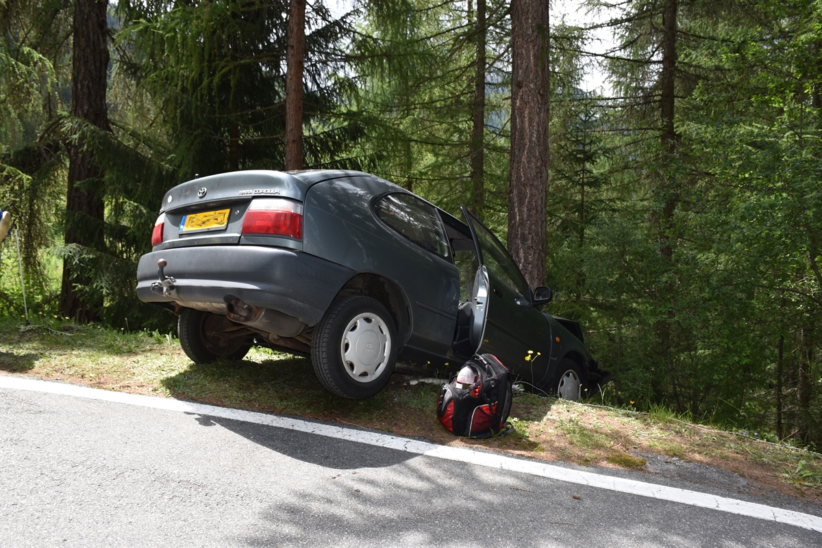 Auto auf abfallender Böschung an Baum