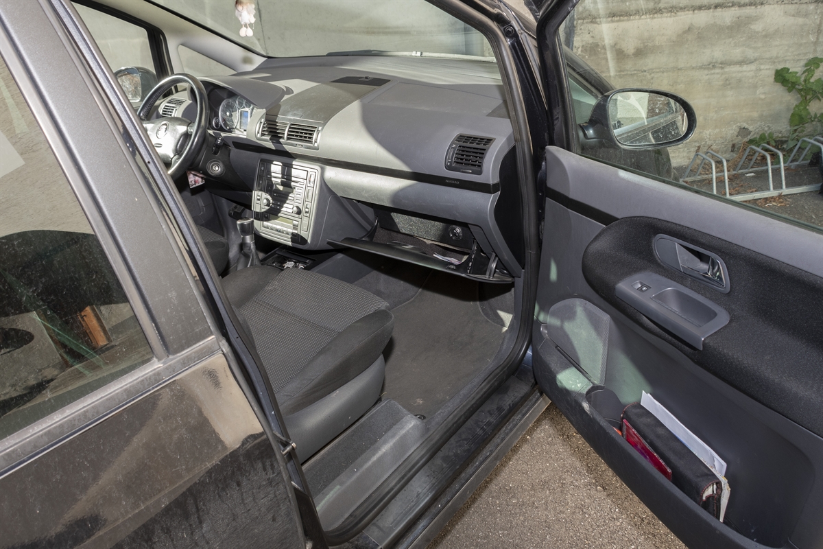 Blick in ein Auto mit offener Beifahrertüre. In der Bildmitte ein ausgeräumtes Handschuhfach.