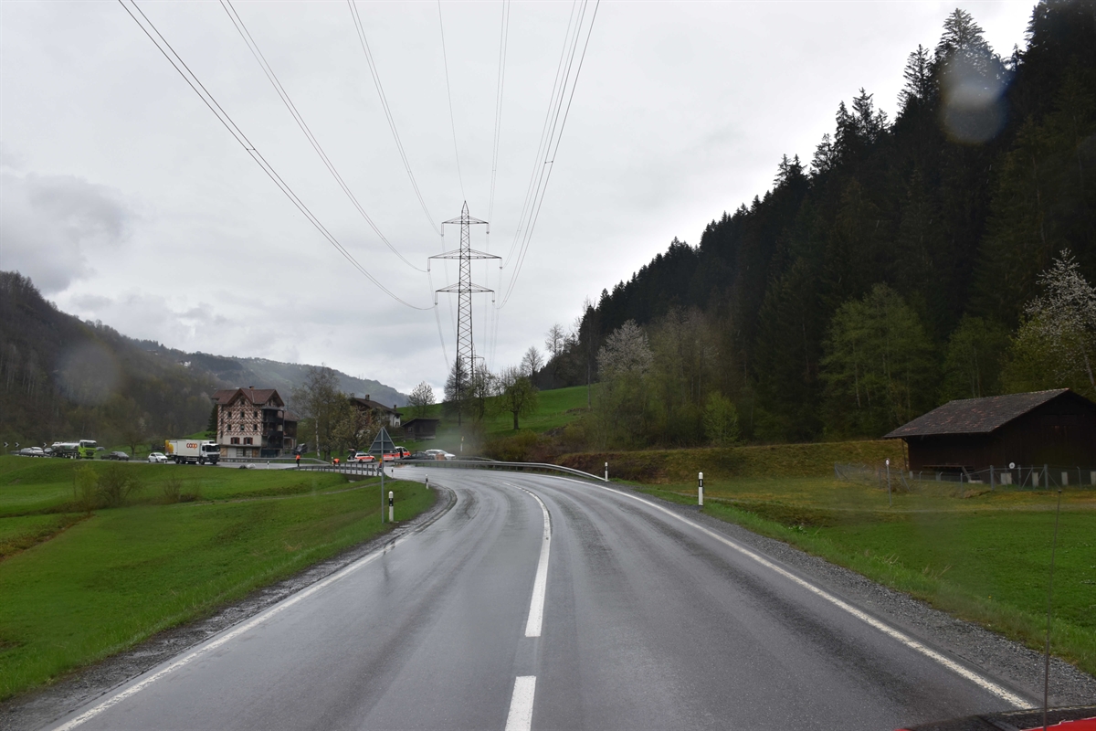 Die Linkskurve in Richtung Ilanz. Am Strassenrand zwei Polizeiautos.