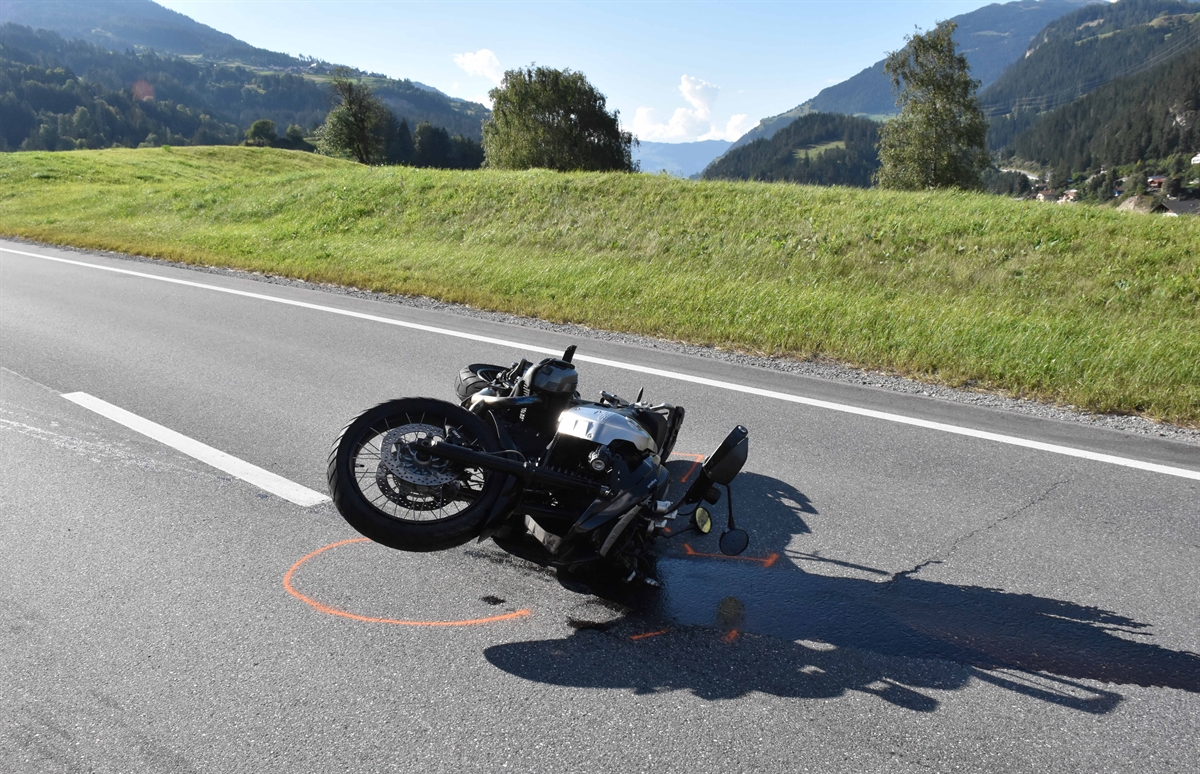 Im Hintergrund Horizont, im Vordergrund das beschädigte Motorrad auf der linken Seite liegend auf der Strasse. 