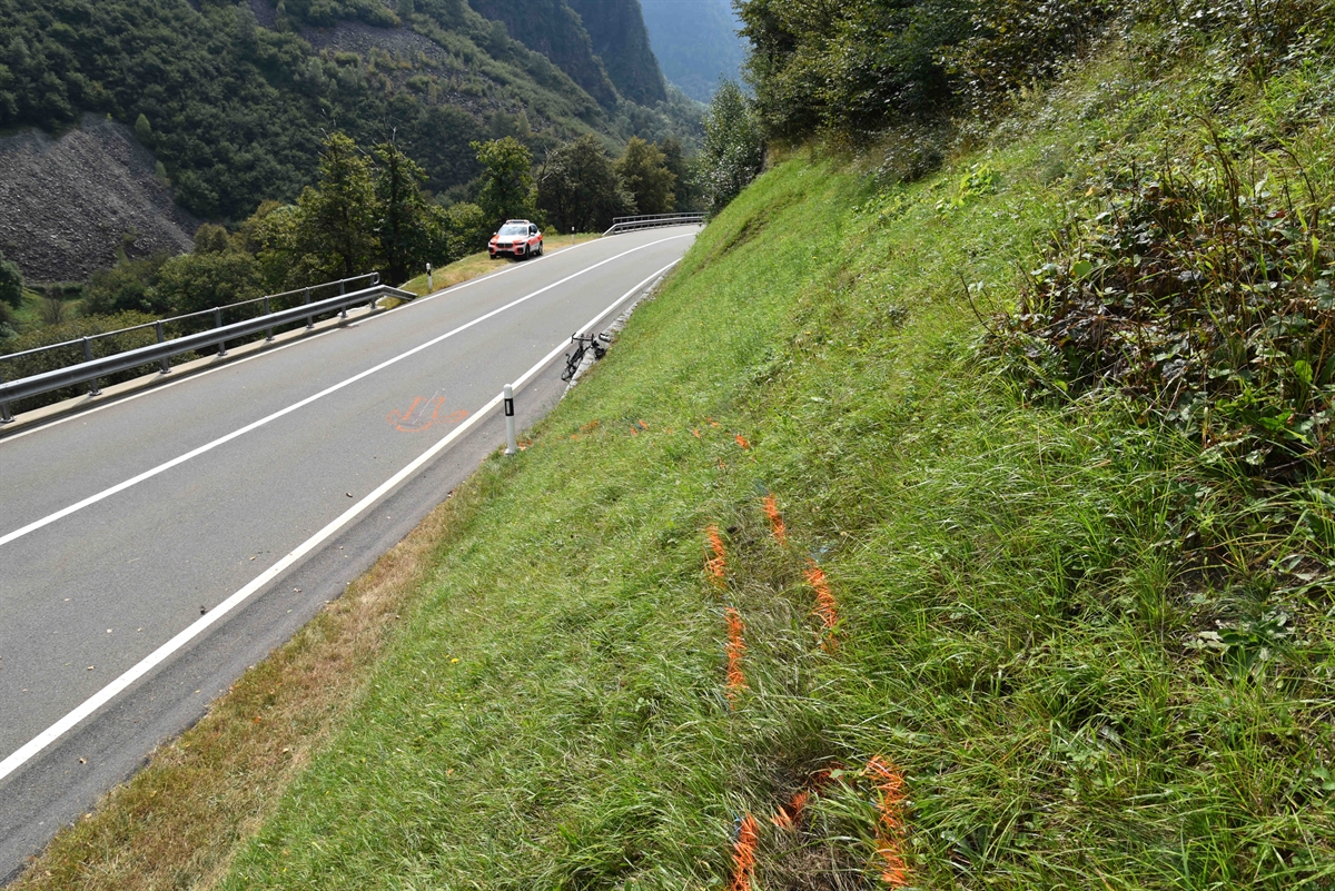 Strasse mit demoliertem Rennvelo und Polizeiauto