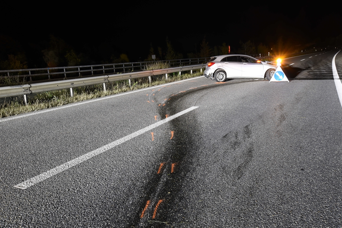 Personenwagen steht querstehend und beschädigt inmitten der Autobahn