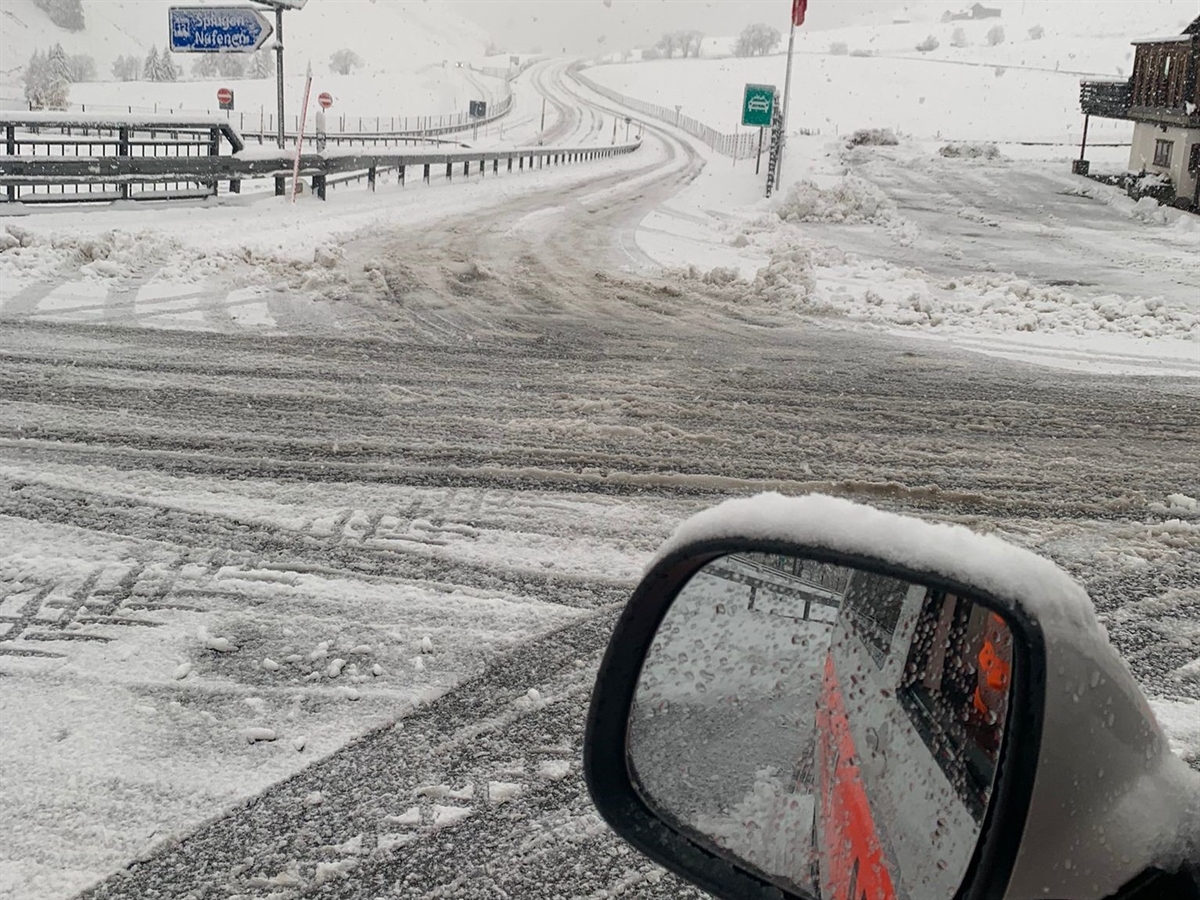 Sicht aus Fahrerposition in einem Polizeiauto, welches sich im Aussenspiegel spiegelt. Im Hintergrund die verschneite Autostrasse N13 ohne jeglichen Verkehr.