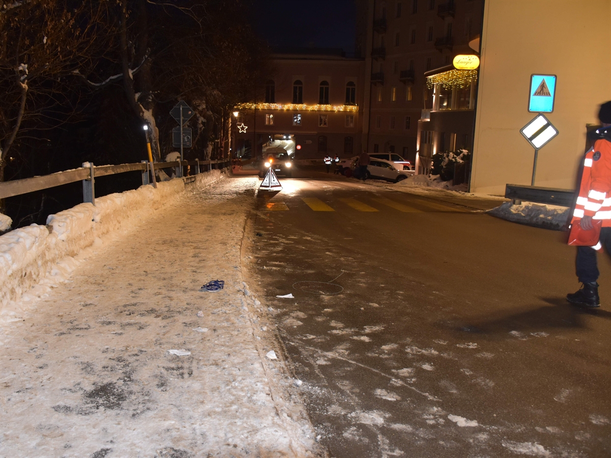 Die Via Retica, es ist dunkel. Rechts ein Polizist, in Bildmitte der Fussgängerstreifen. Links ein verschneites Trottoir.