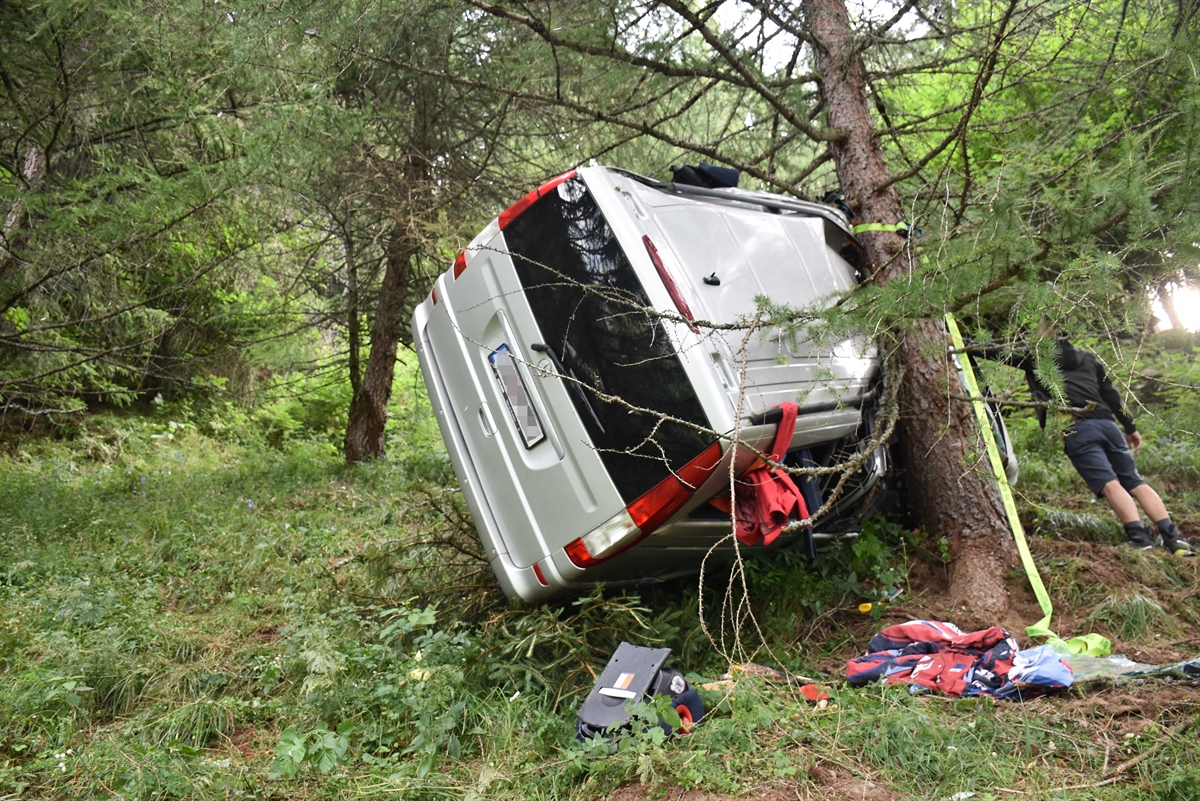 Sehr steile Böschung unterhalb Waldweg. Kleinbus mit Dach an Baum.