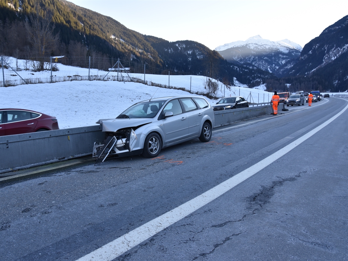 Das Unfallauto steht ganz an der Mittelleitplanke auf der Südspur der N13. Zwei Mitarbeiter des TBA GR sind bei der Reparatur des Aufprallschutzes.