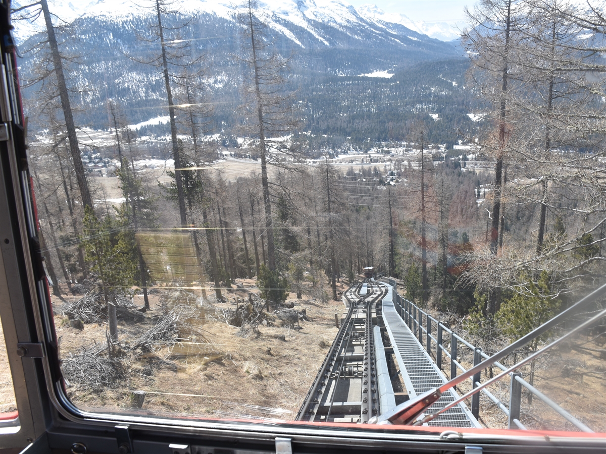 Aus der Führerperspektive der Standseilbahn sieht man in Richtung Tal die Gleise, rechts davon die parallel führende Metalltreppe und weiter unten die Kreuzungsstelle sowie die zweite Kabine.