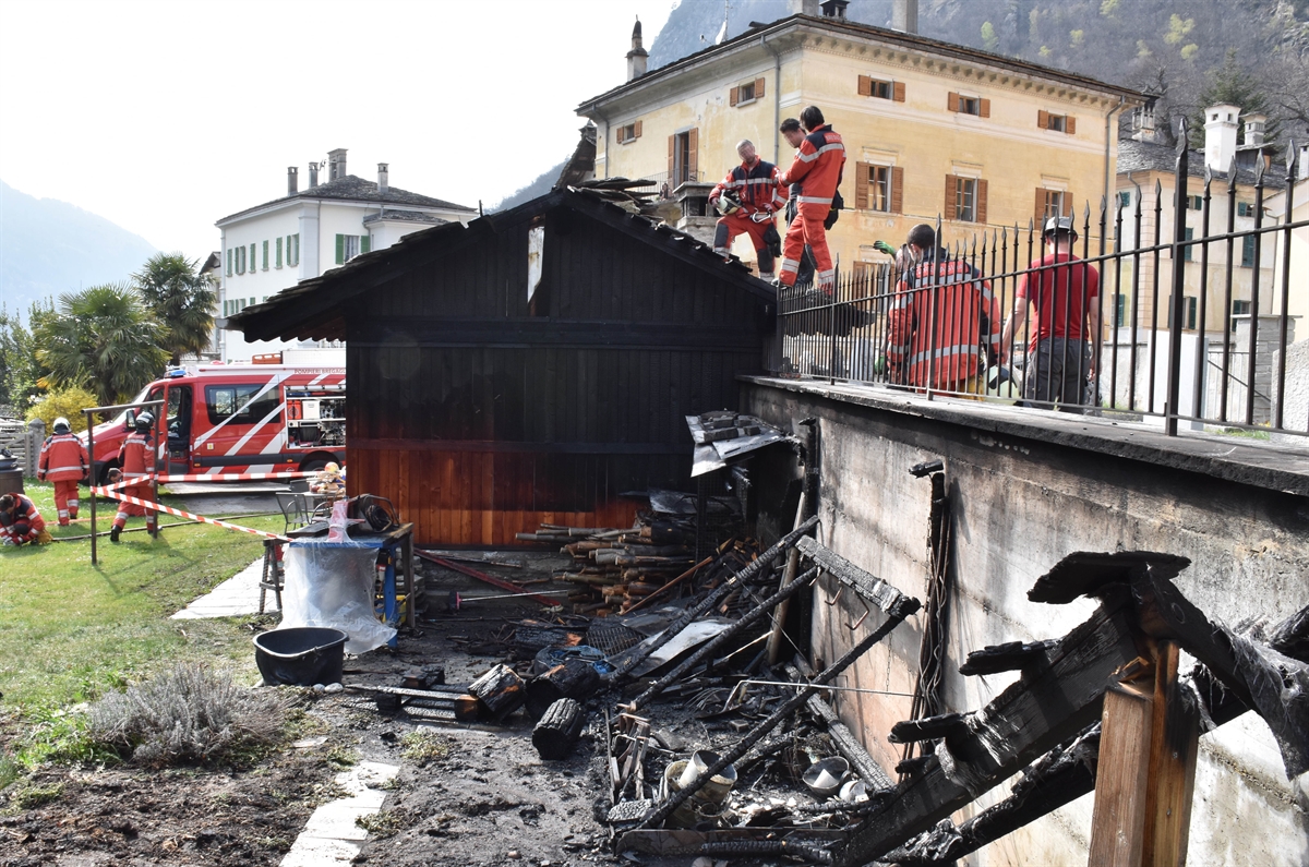 Feuerwehrleute und verbrannte Gartenhäuser