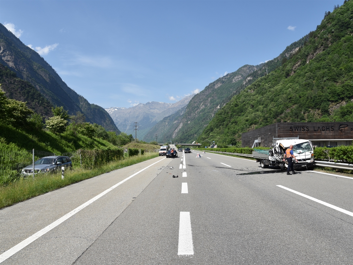 Autobahn A13 beim Anschluss Lostallo in Richtung San Bernardino gesehen. Links im Wiesland steht der Personenwagen. Der Lieferwagen steht auf der Überholspur bei der Mittelleitplanke. Ein Polizist begutachtet die Front des Lieferwagens