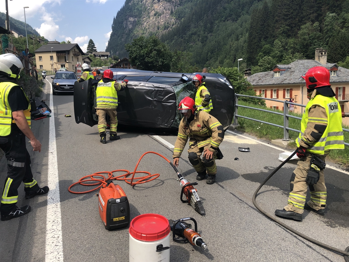 Die Einsatzkräfte der Strassenrettung bei ihrer Arbeit am auf der Seite liegenden Auto.