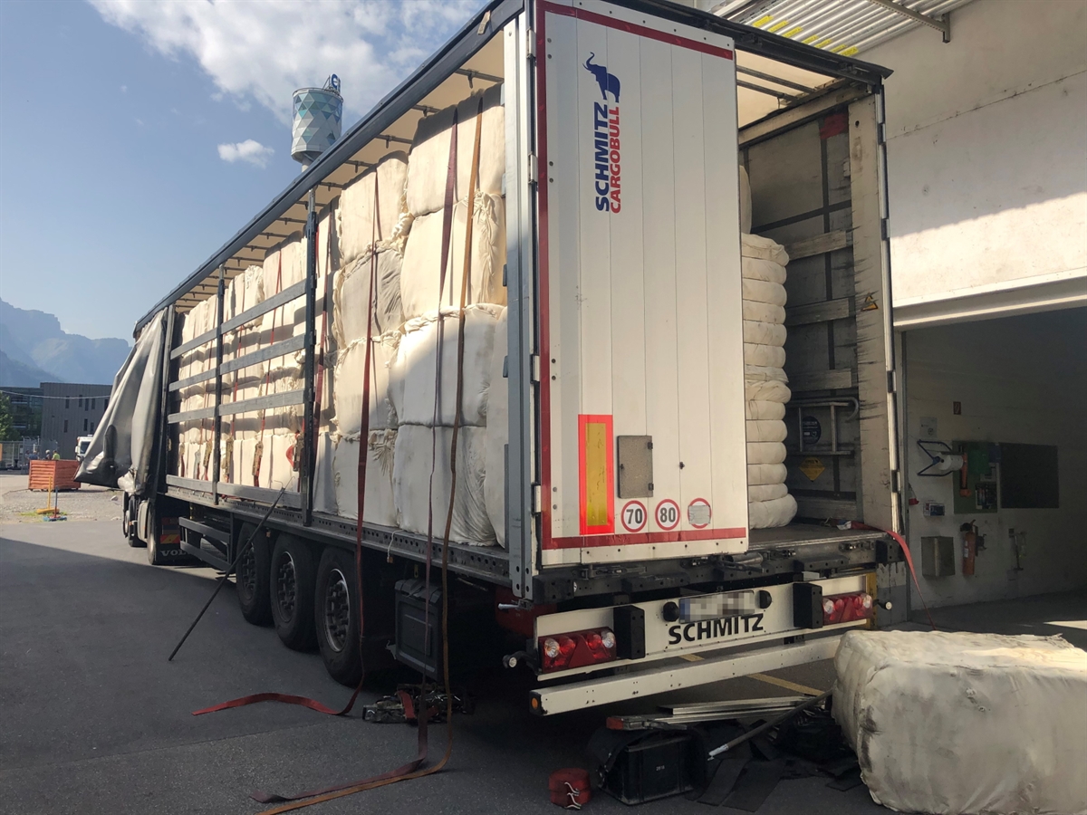Das Sattelmotorfahrzeug vor einer Halle. Hinter dem Auflieger liegt der ca. 200 Kg schwere Baumwollpaket auf dem Boden.