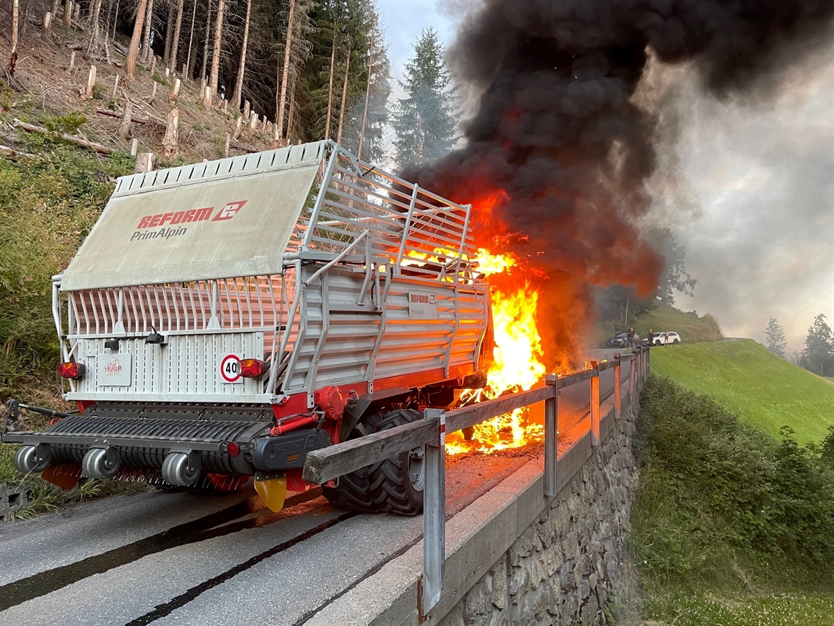 Flammen und Rauch steigen aus der Führerkabine des Heuladers