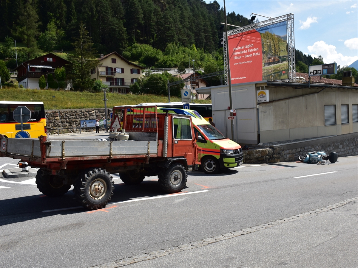 Das landwirtschaftliche Gefährt steht auf der linken Fahrbahnhälfte. Hinter diesem ein Ambulanzfahrzeug und rechts davon liegt der Roller.