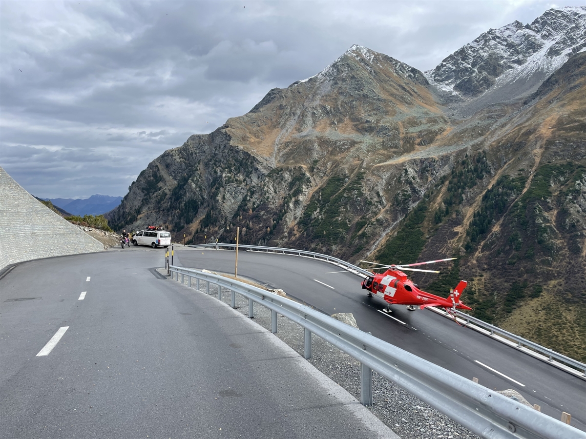 Die Kurve in welcher der Motorradfahrer die Herrschaft über sein Gefährt verlor. Auf der Fahrbahn steht ein Helikopter der Rega, welcher demnächst startet.