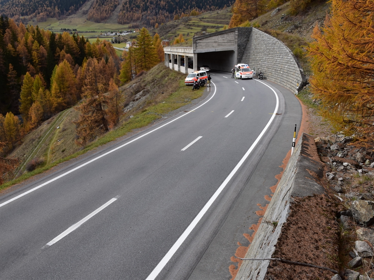 Der Eingang der Galerie. Auf der talseitigen Fahrspur steht das Ambulanzfahrzeug. Auf der linken Bildseite steht ein Patrouillenfahrzeug der Kantonspolizei Graubünden.