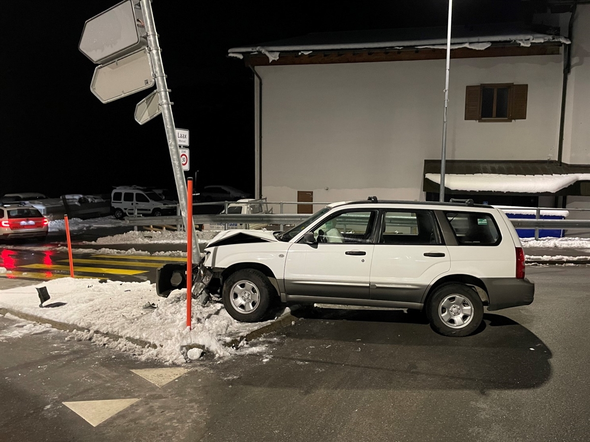 Das verunfallte Auto seitlich von links. Links von der eingedrückten Front ein beschädigter Signalständer. Im Hintergrund ein Haus.