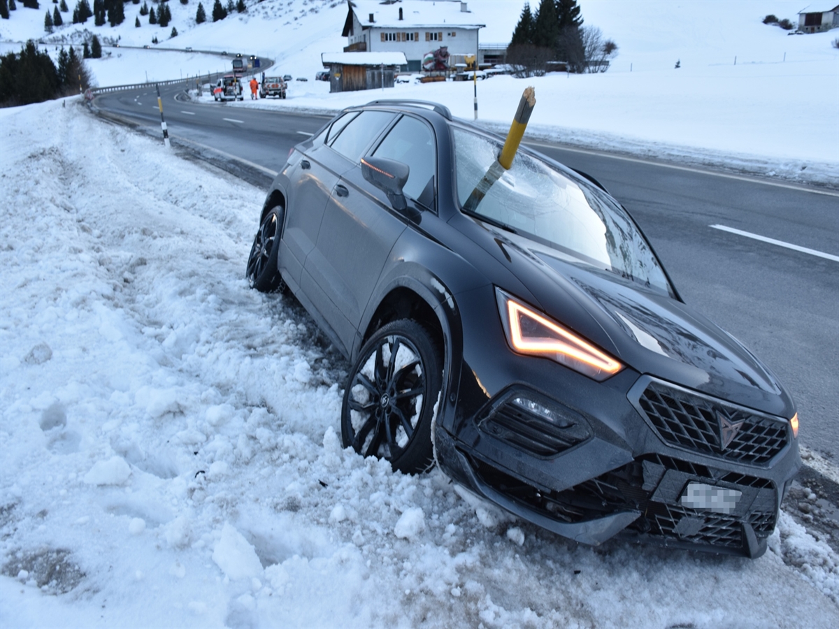 Im Vordergrund das auf dem Schnee zum Stillstand gekommene Auto. Eine gebrochene Schneelatte inmitten der Frontscheibe. Rechts davon die Strasse.