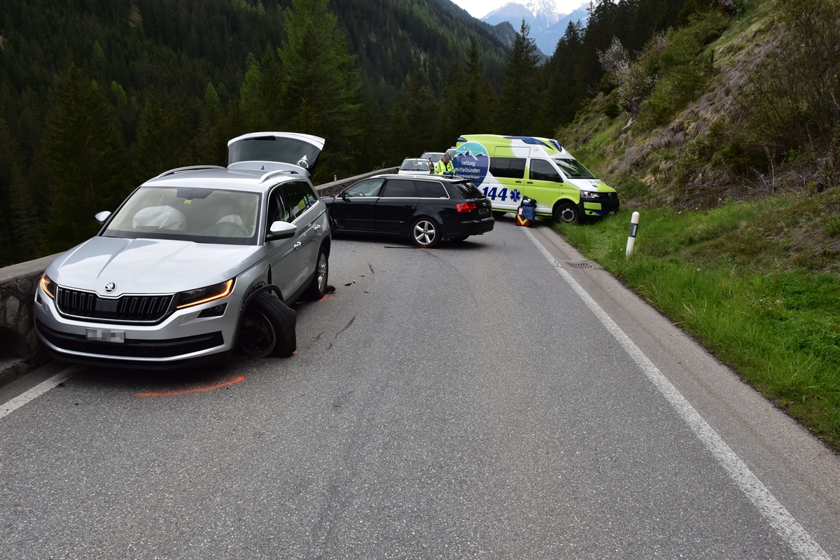 Strassenverlauf der Albulastrasse im Bereich der Unfallstelle, Höhe God da Streda, in Fahrtrichtung Filisur gesehen. Im Vordergrund links ein beteiligtes silberfarbenes Fahrzeug, dahinter das zweite dunkle beteiligte Fahrzeug zu erkennen. Im Hintergrund noch der Rettungswagen zu erkennen.