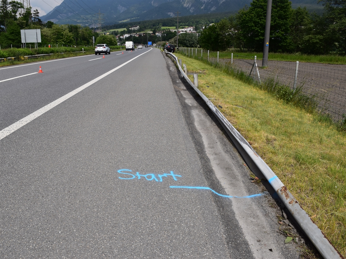 Nordspur der Autobahn A13 mit dem Beginn der Leitplanke, über welche der Verunfallte gefahren ist. Am Ende dieser ist in der Ferne das leicht seitlich gekippte Unfallauto erkennbar.