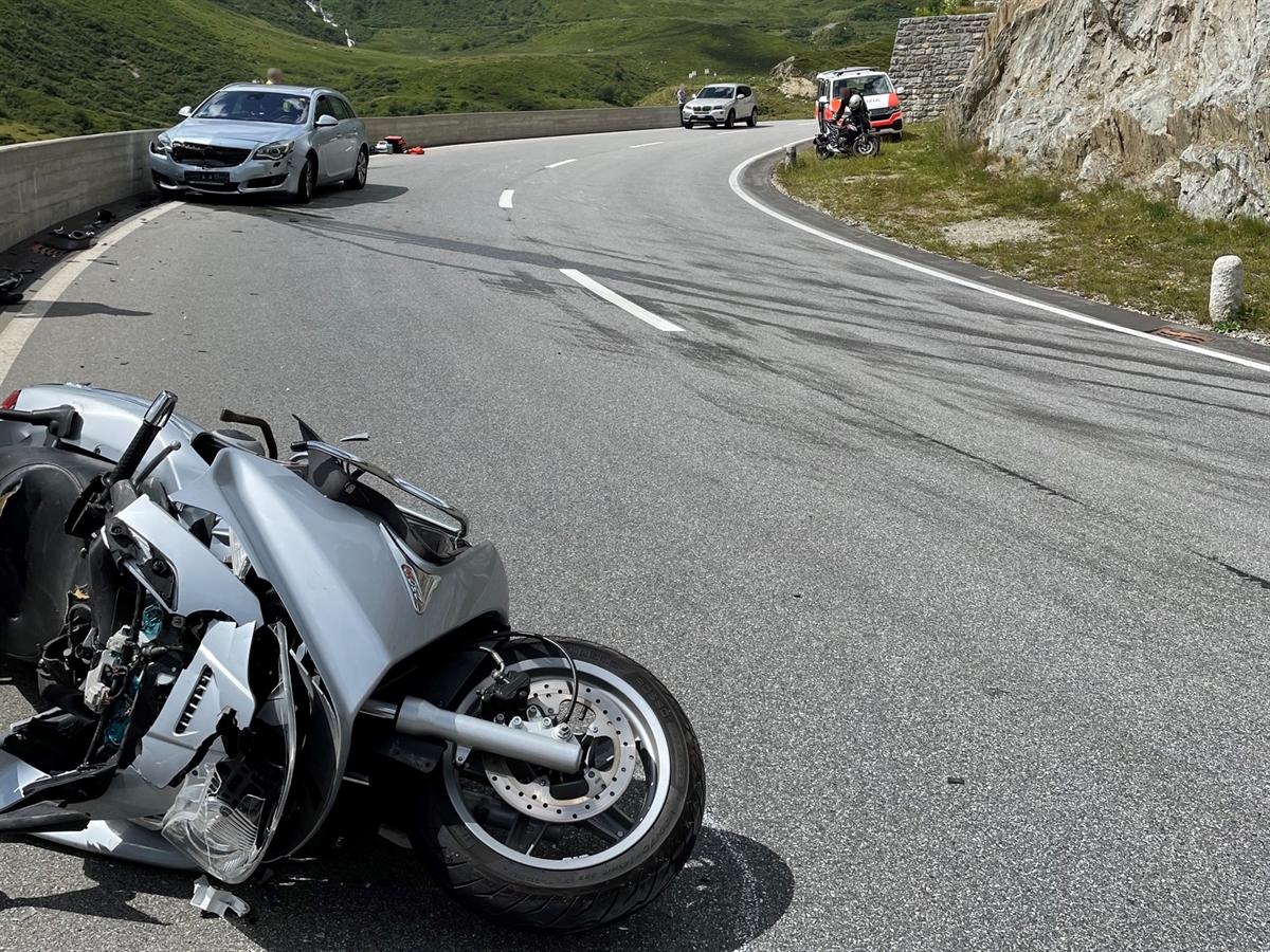 Im Vordergrund liegt das Motorrad auf der Seite liegend auf der Fahrbahn. Im Hintergrund das Unfallfahrzeug des Deutschen. Weiter hinten auf der Strasse ein Polizeiauto sowie ein Auto eines unbeteiligten Verkehrsteilnehmers.