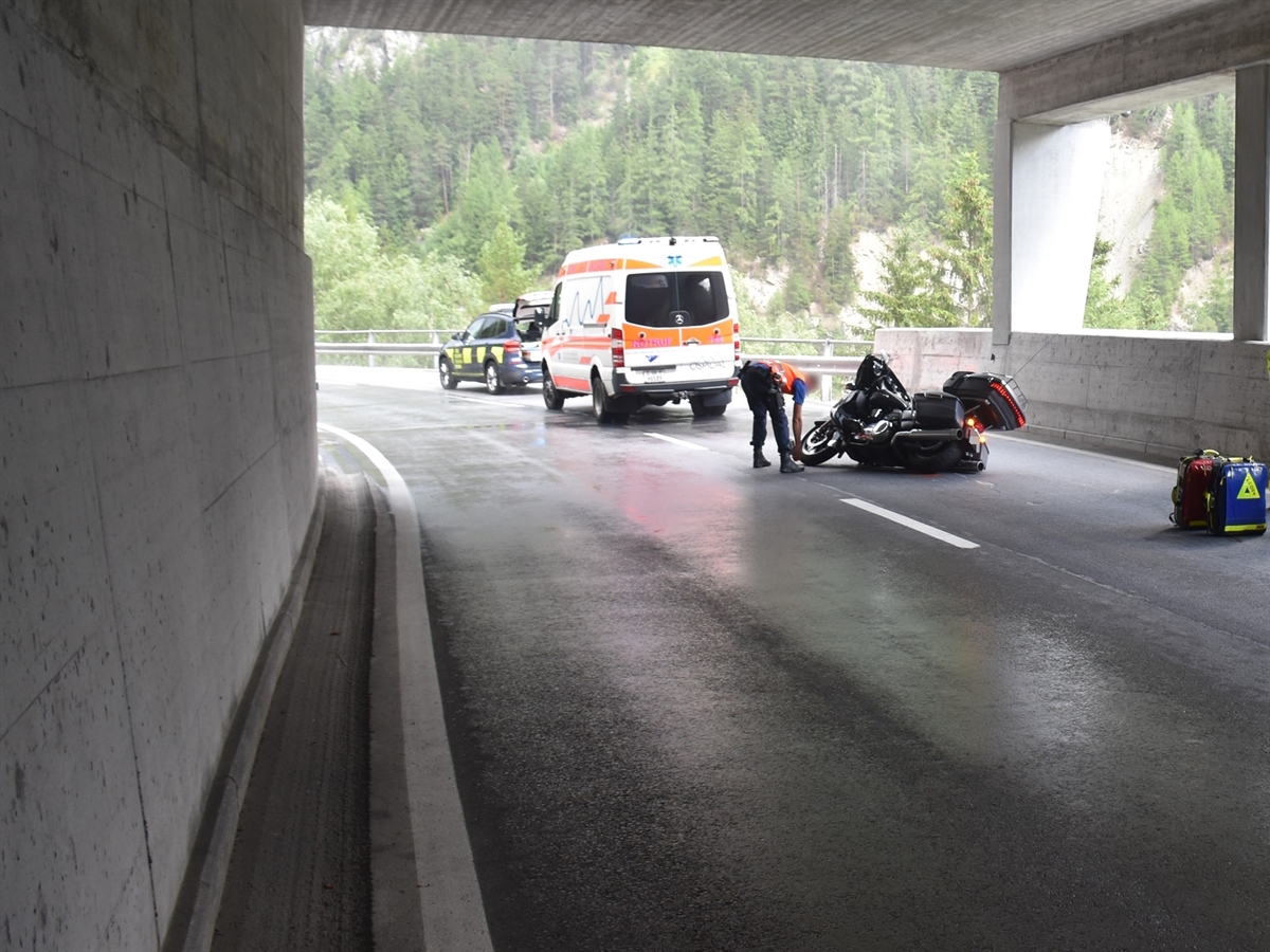Motorrad liegt in der Galerie auf der Seite. Ein Polizist markiert die Endlage. Hinter ihm steht ein Fahrzeug der Rettung sowie des BAZG.
